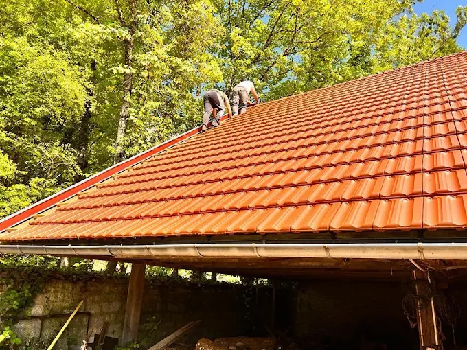 Deux couvreurs sur un toit.