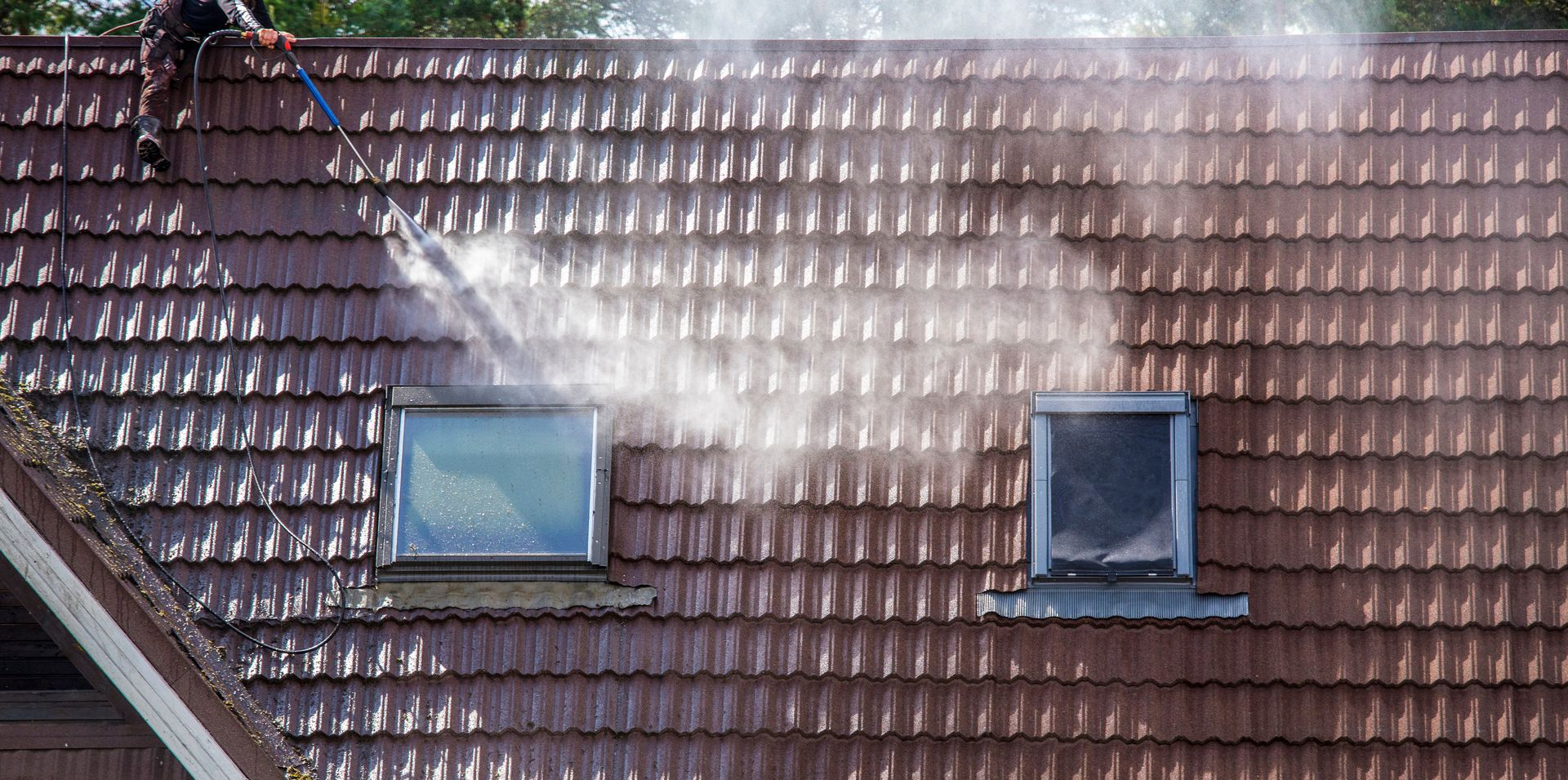 Un jet à haute pression sur un toit avec deux fenêtres de toit.
