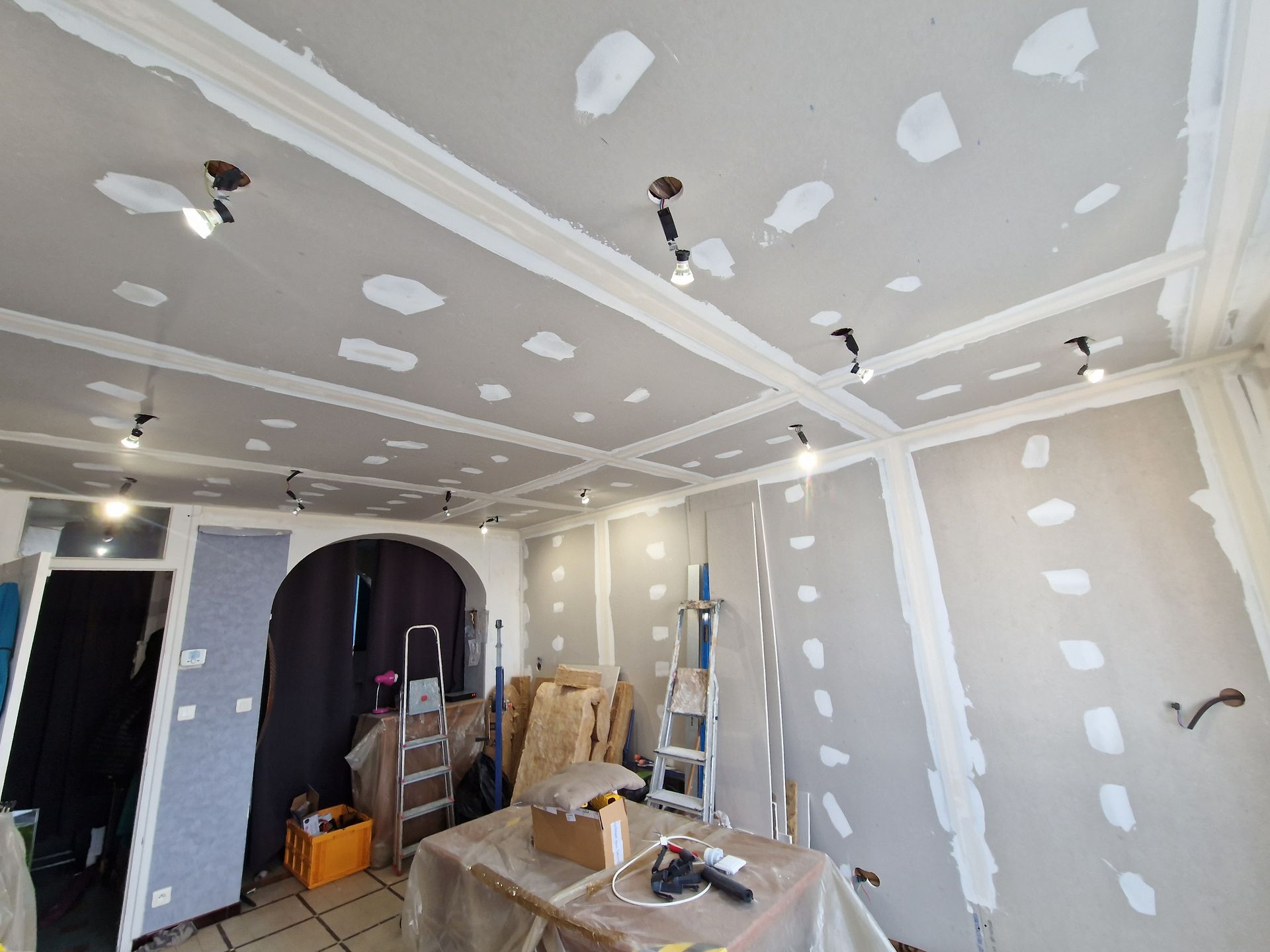 Pose de plaques de plâtre avec l'enduisage des bandes dans une pièce