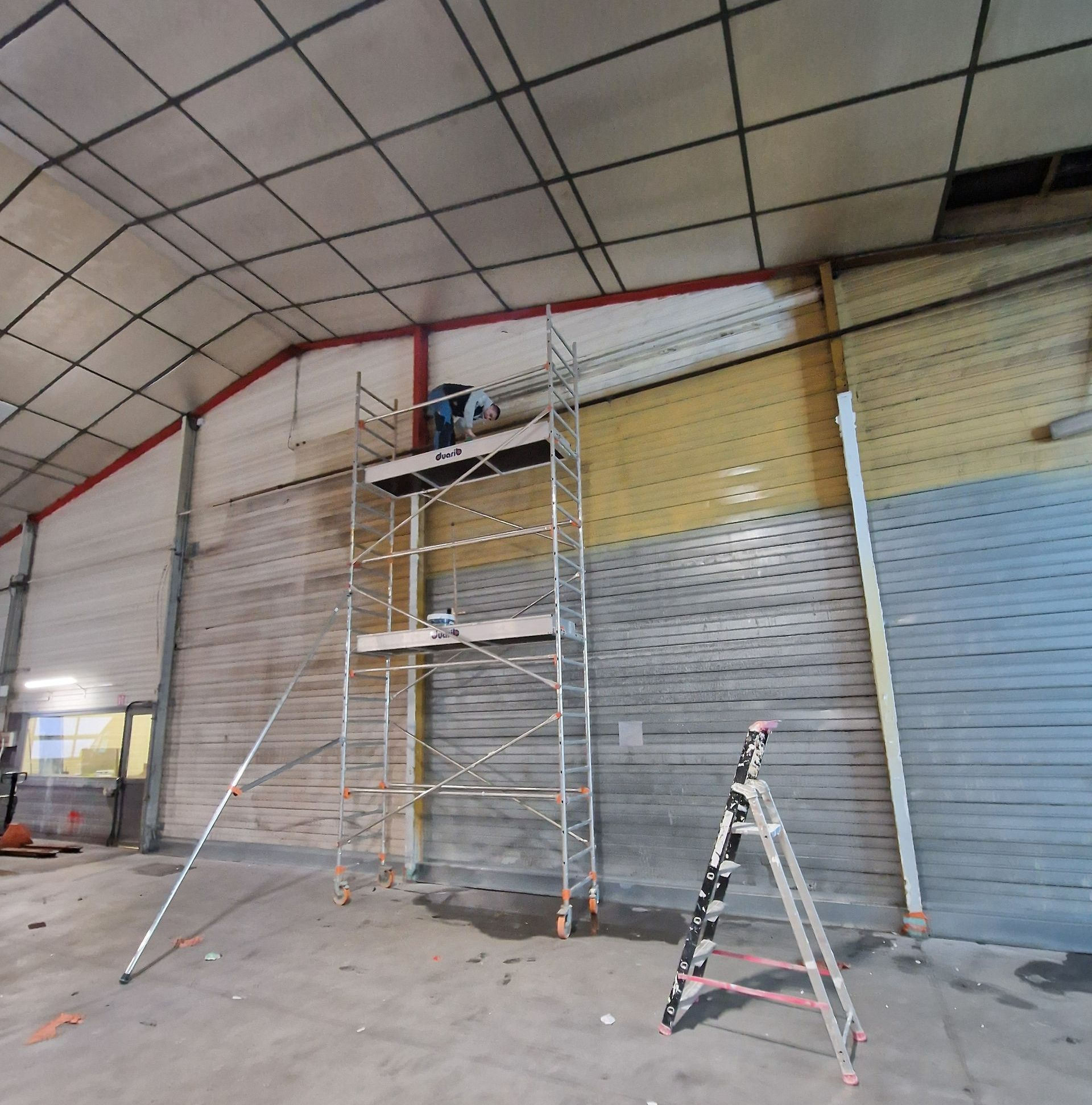 Un échafaudage et un escabeau pour les travaux de peinture dans un hangar