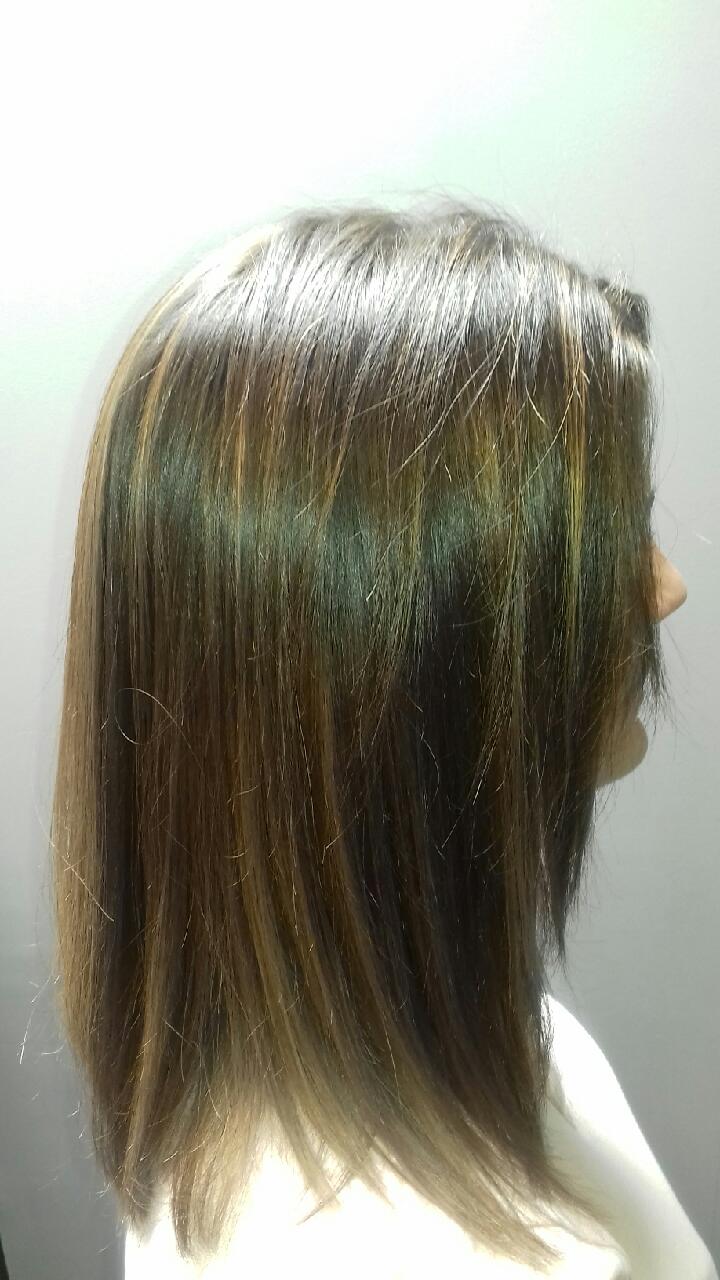 Cheveux avec des mèches, châtain foncé avec des mèches blondes, raides et mi-longs.