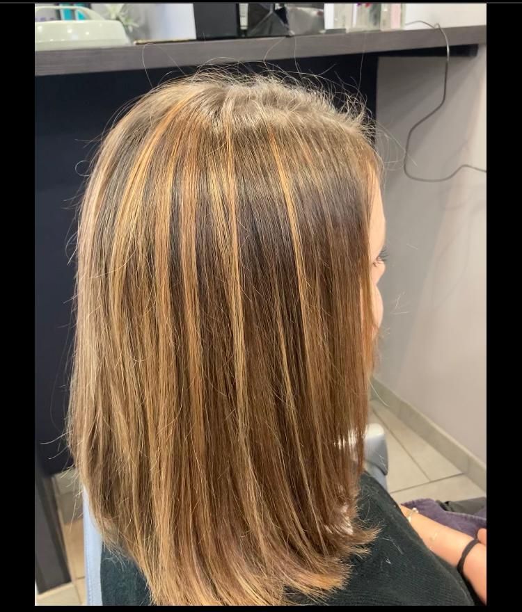 Femme aux cheveux bruns mi-longs et méchés.