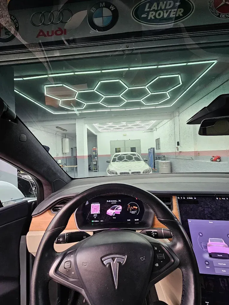 Tesla frente a una sala de exposición de automóviles con luces de techo geométricas