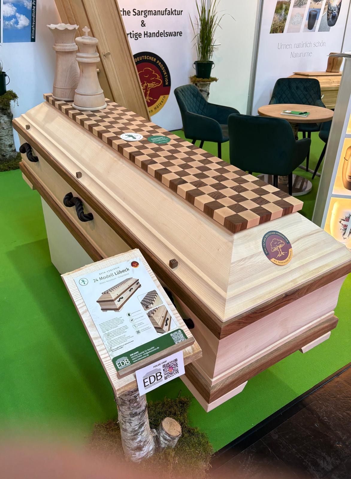 Decorative coffin-like display on a green floor at an indoor exhibition booth