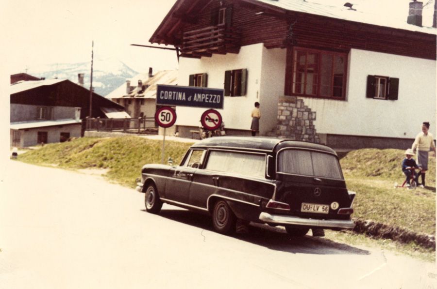 Altes Fahrzeug des Bestattungshauses vor einem Gbeäude