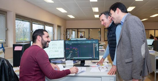 Trois personnes autour d'un bureau