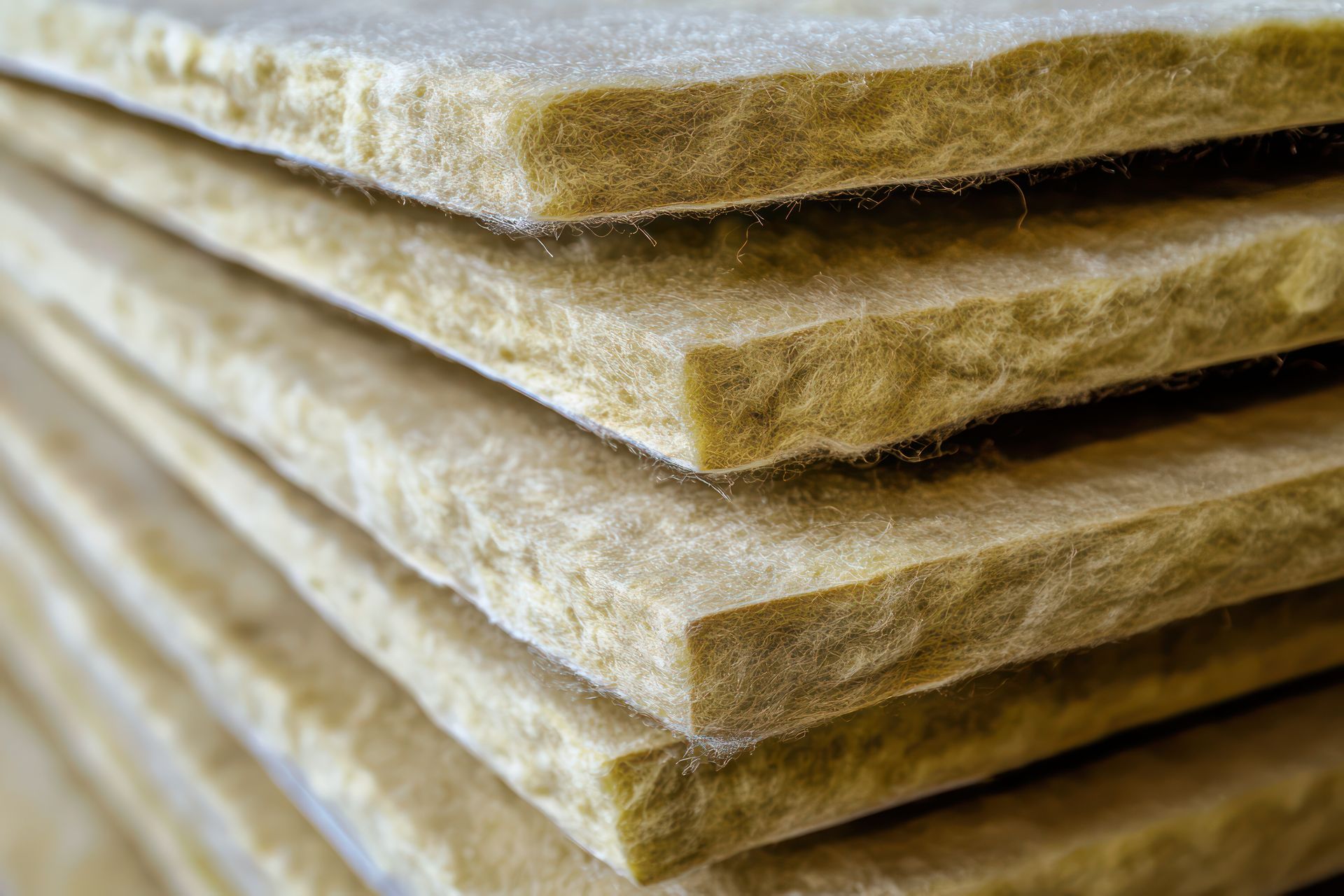 Pile de panneaux isolants fibreux brun clair.