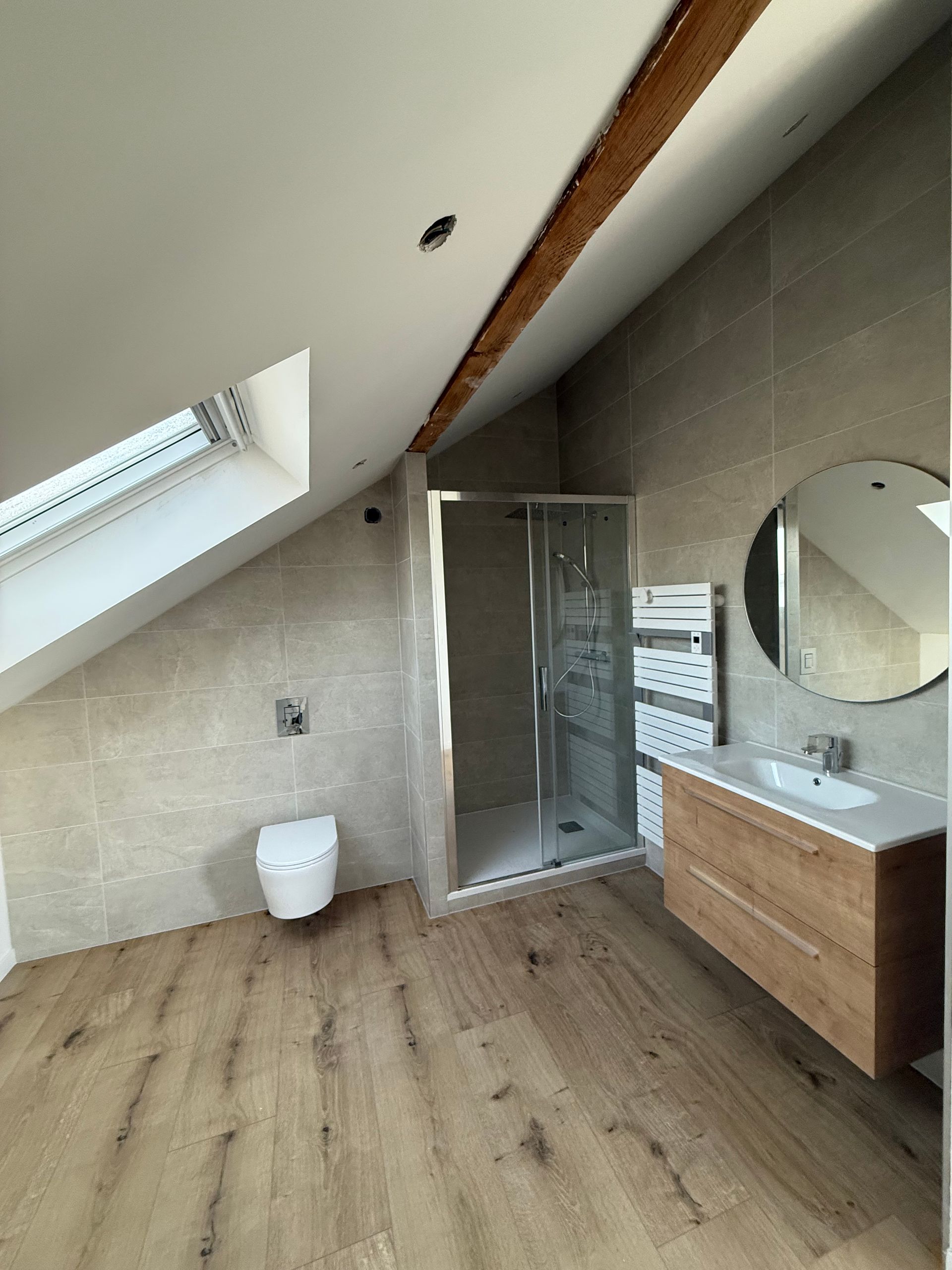 Intérieur d'une pièce en cours de rénovation, avec murs apparents, poutres de soutien et matériaux de construction.