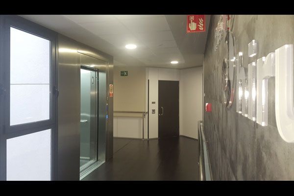 Un pasillo largo con un extintor de incendios en la pared.