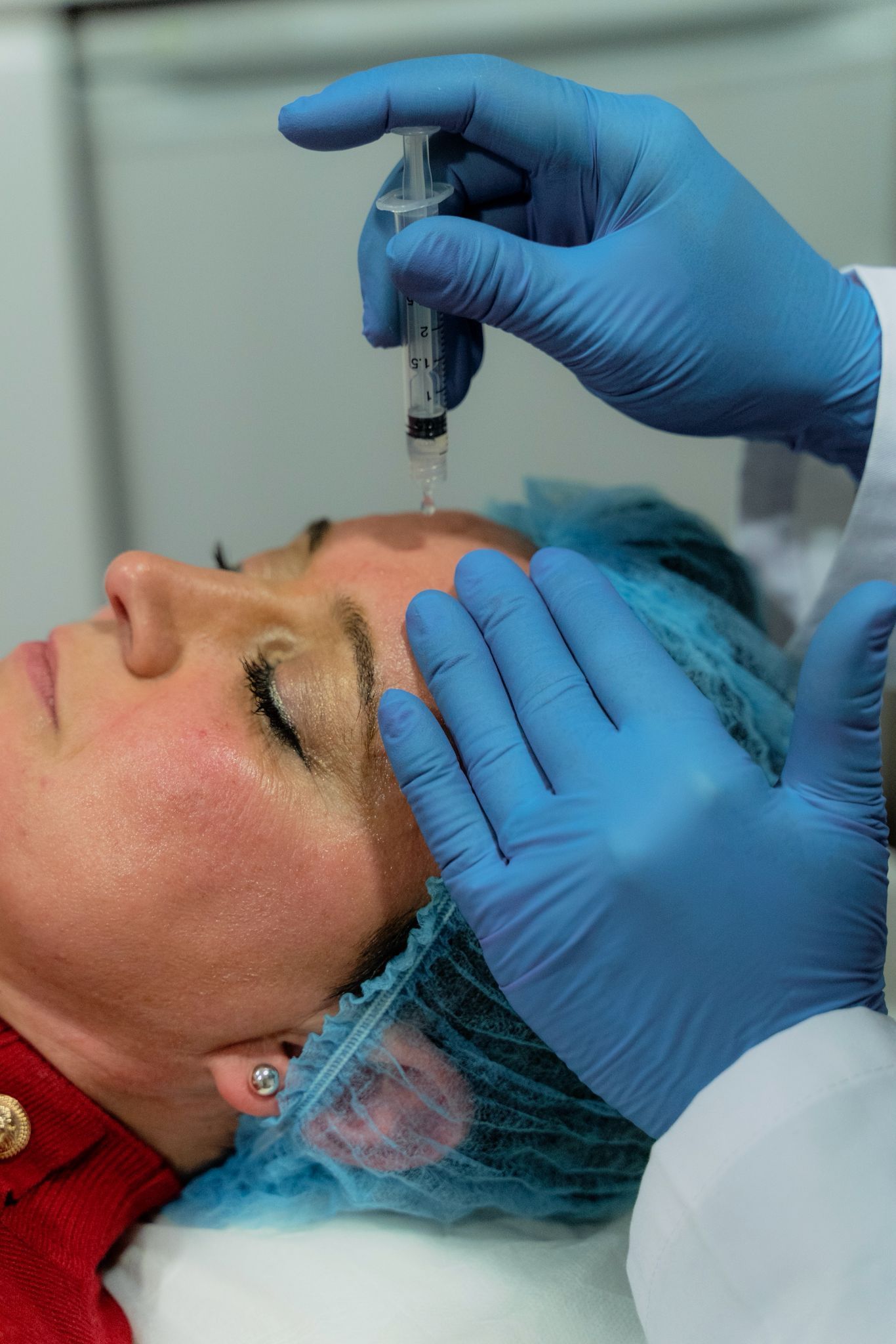 Persona que recibe un tratamiento de contorno corporal con un dispositivo portátil en la pierna en una clínica.