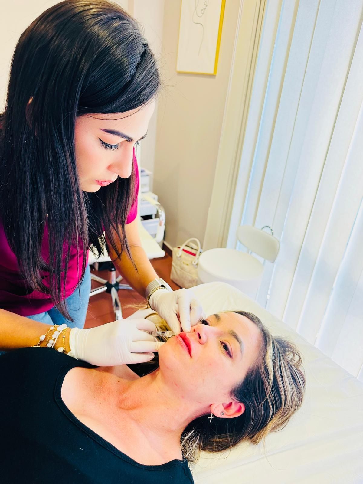 Persona que administra un tratamiento de piernas con un dispositivo portátil a un cliente en un spa.