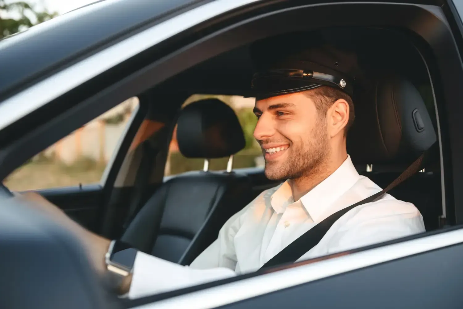 Un hombre está sentado en el asiento del conductor de un coche.