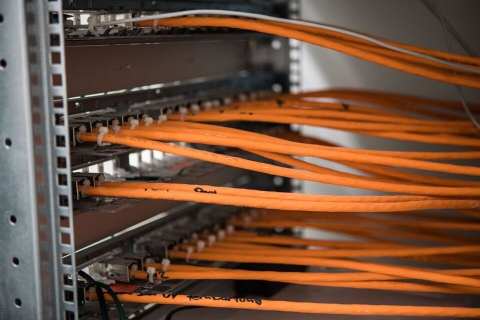 Rickli Elektro GmbH – Netzwerkkabel führen geordnet aus einem Serverschrank