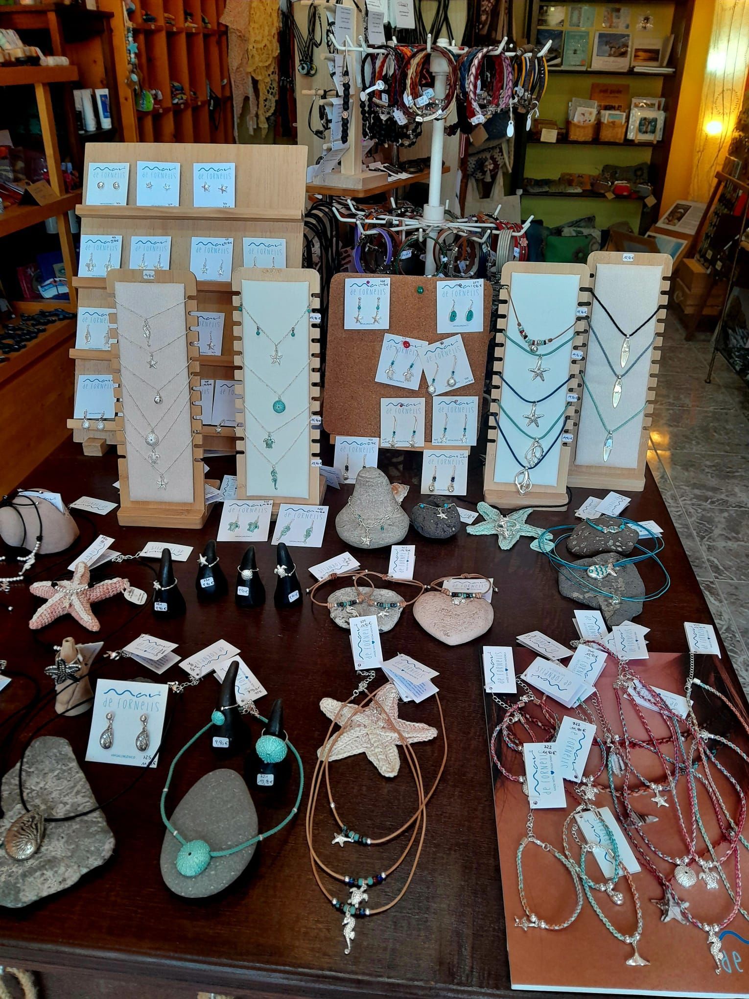 Una exhibición de aretes y collares colgados en una pared.