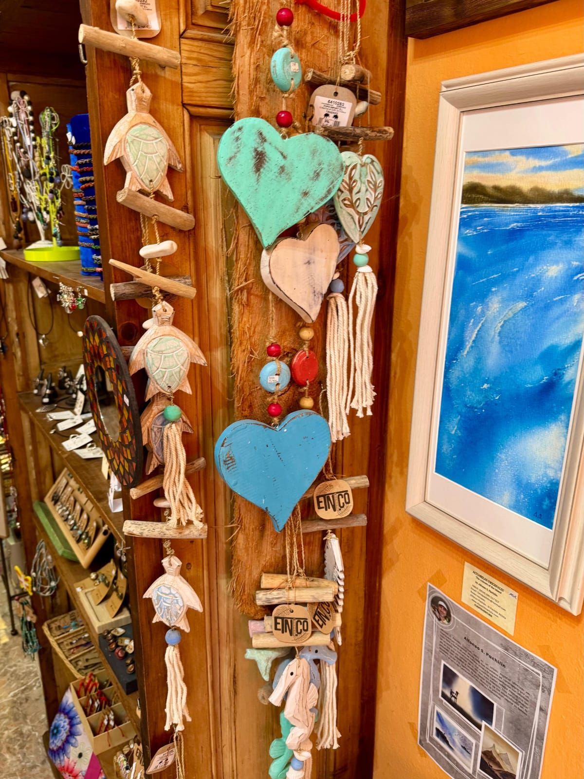 Un estante lleno de una variedad de cerámicas y pinturas.