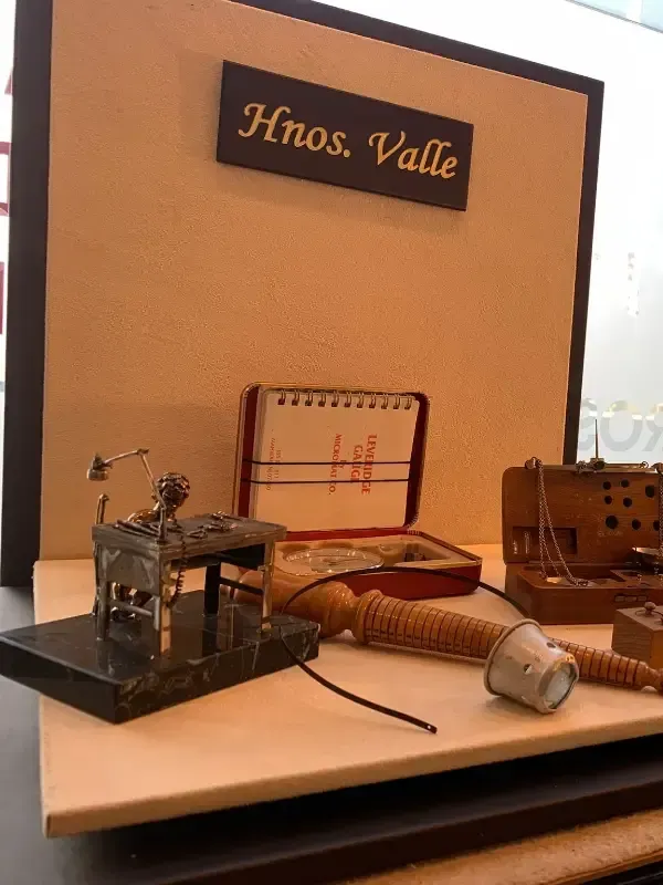 Exhibición de taller en miniatura con herramientas pequeñas, una cama y un letrero negro que dice “Años Vale”.