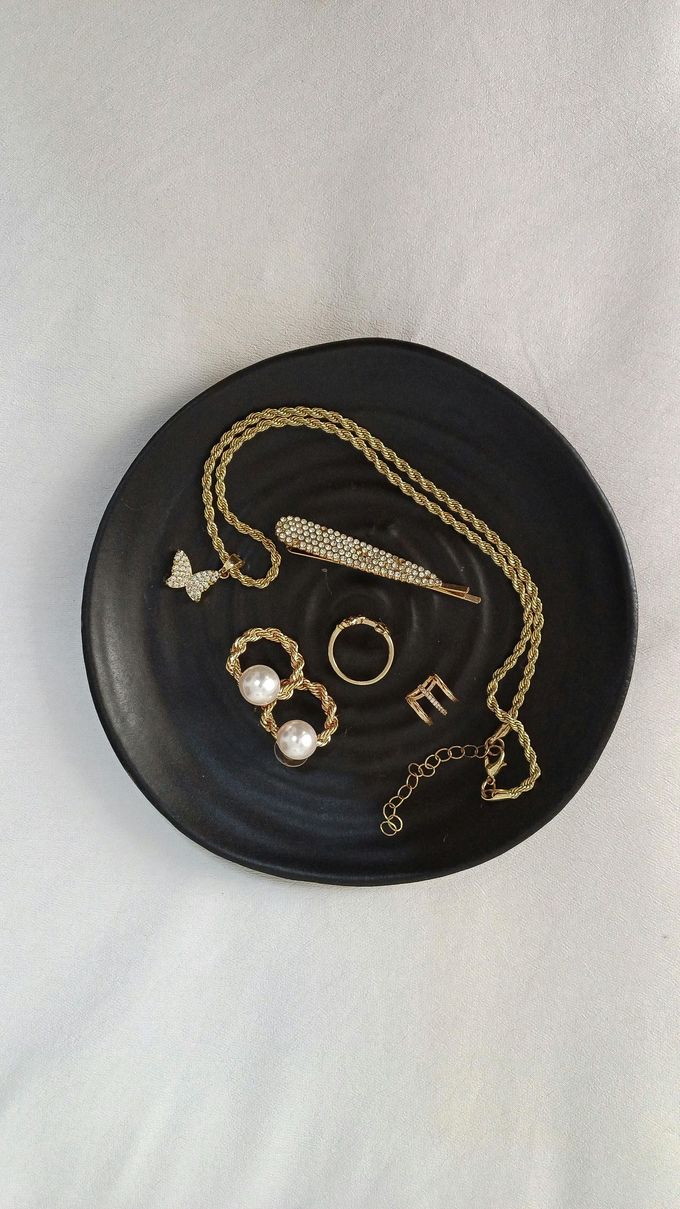 Exhibición de joyas y anillos de oro en bandejas en el mostrador de una tienda.