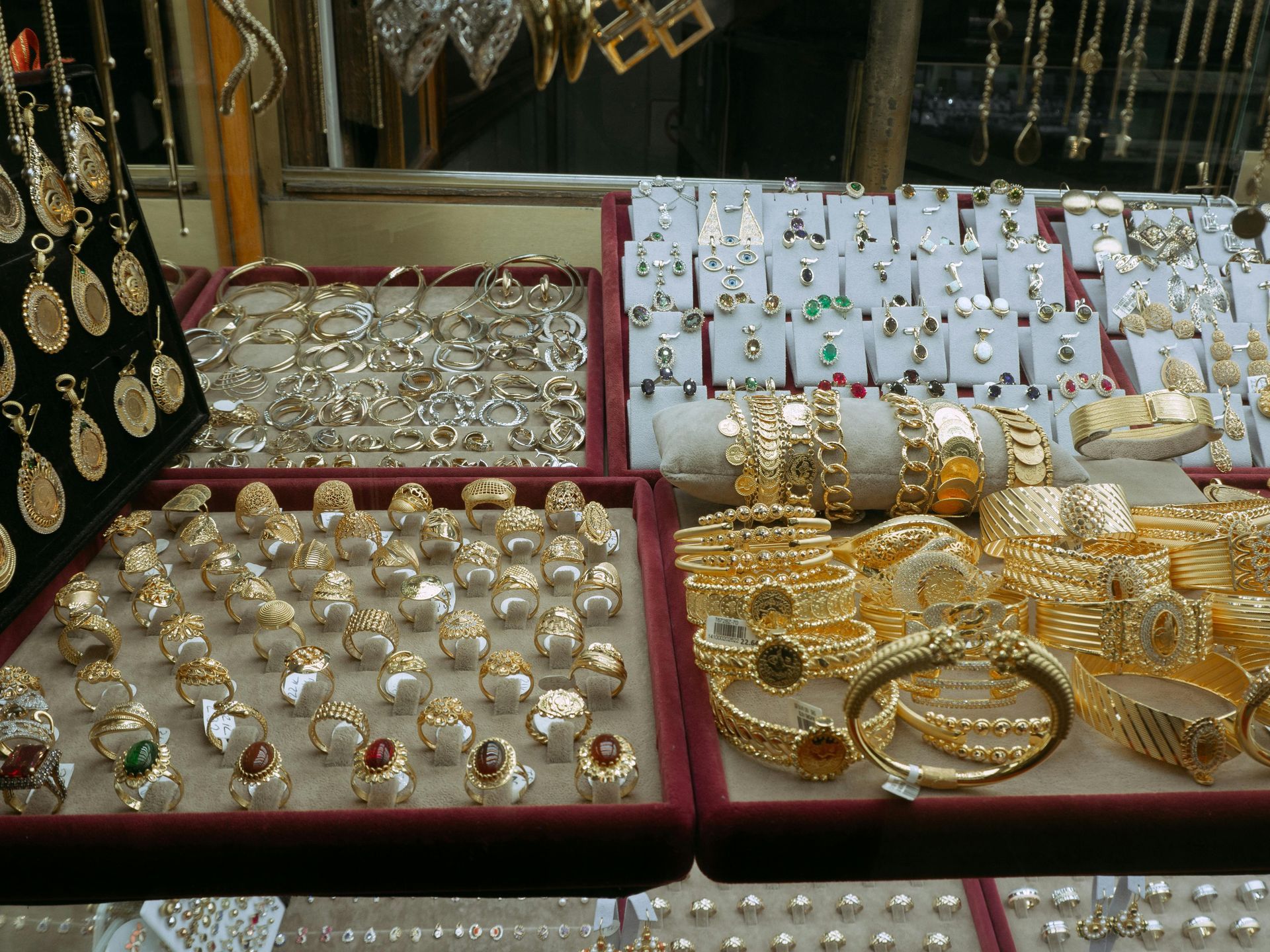 Exhibición de joyas y anillos de oro en bandejas en el mostrador de una tienda.