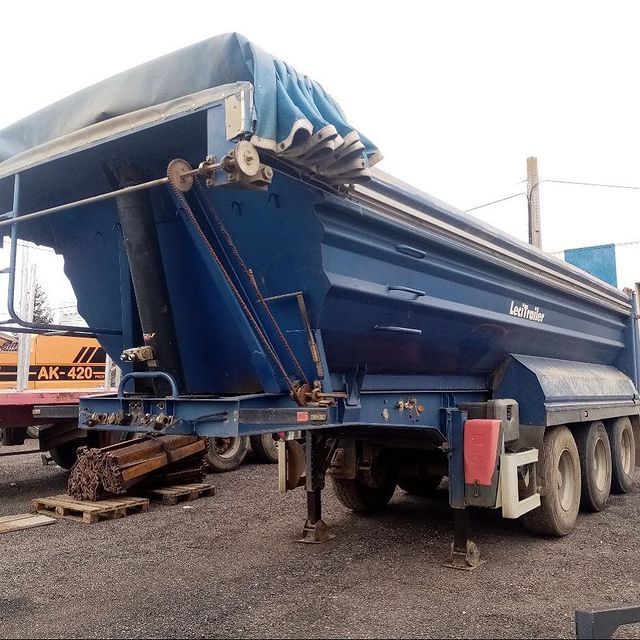 Un camión volquete azul con el número 420 en el costado.