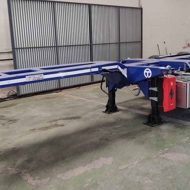 Un remolque azul y blanco está estacionado en un almacén.