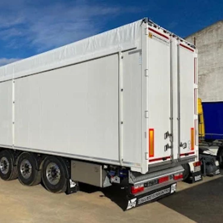 Un camión semirremolque blanco está estacionado en un estacionamiento.