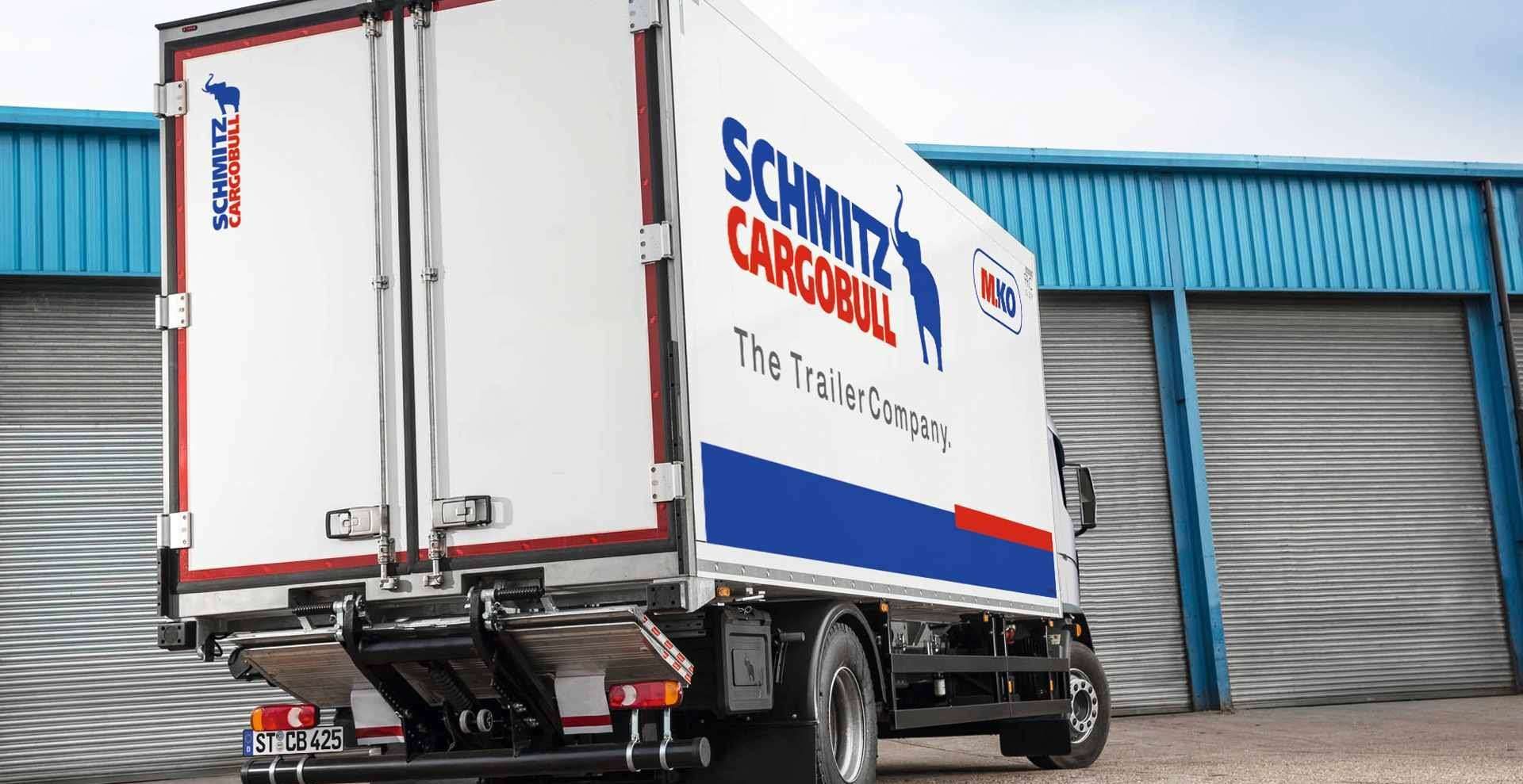 Un camión de carnaval de Schmitz está estacionado frente a un edificio.