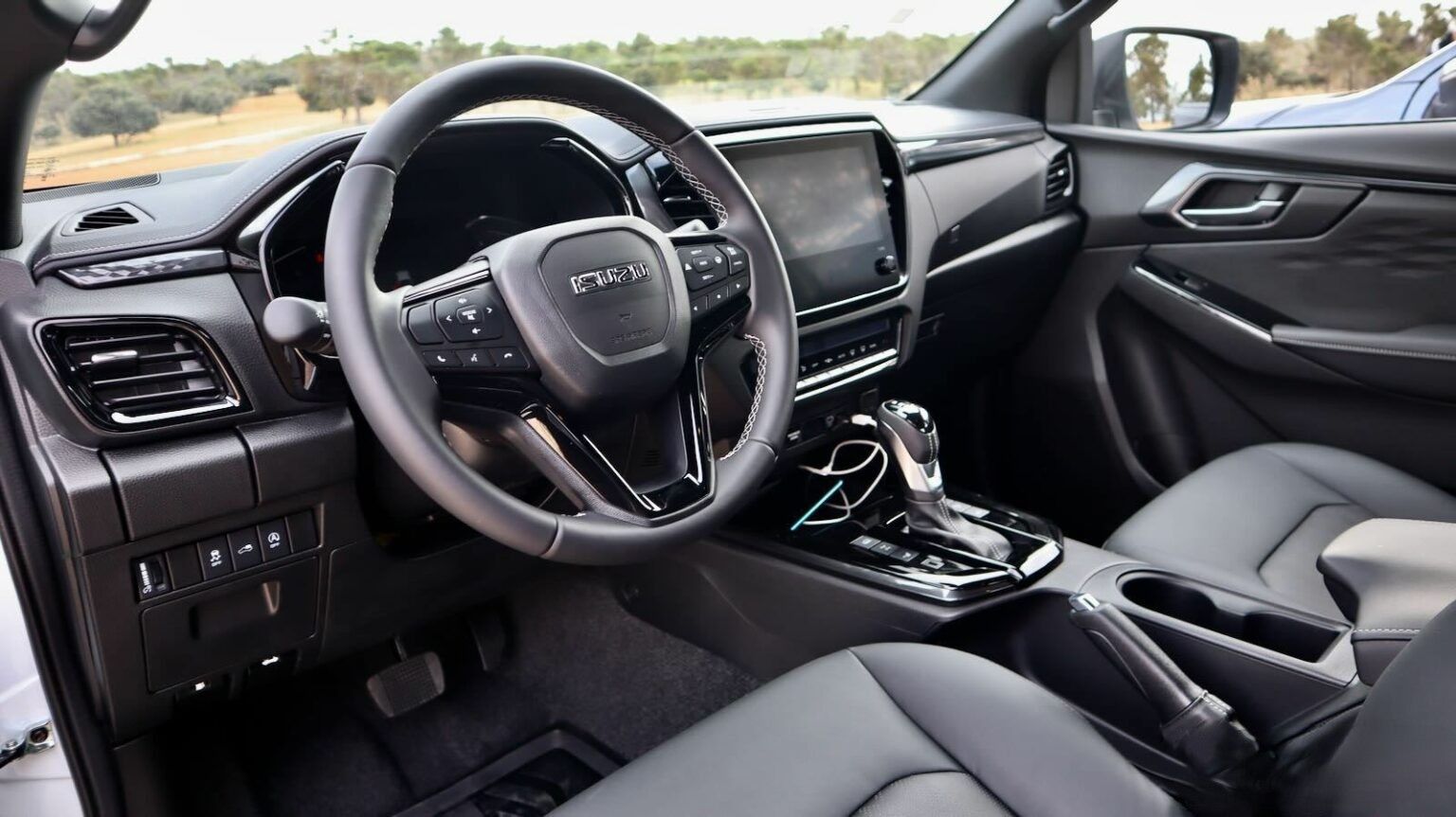 El interior de un coche con volante y asientos.