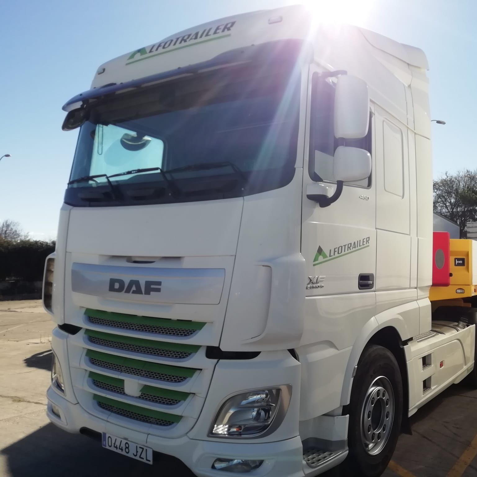 Un camión semirremolque DAF blanco está estacionado en un estacionamiento.