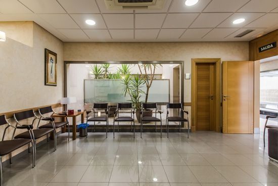 Una sala de espera con muchas sillas y una ventana.