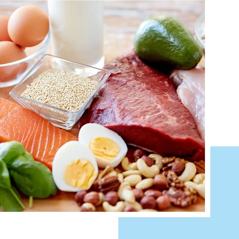 Una mesa cubierta con carne, huevos, nueces y un vaso de leche.