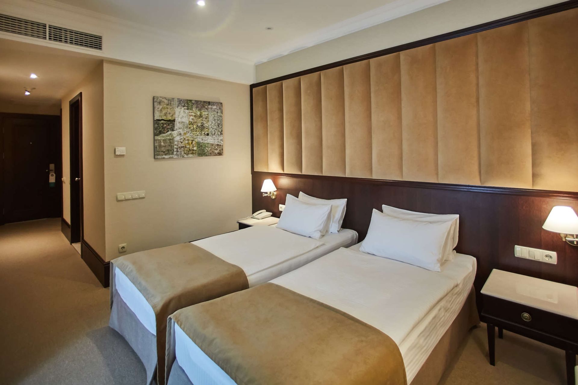Una habitación de hotel con dos camas y una mesita de noche.