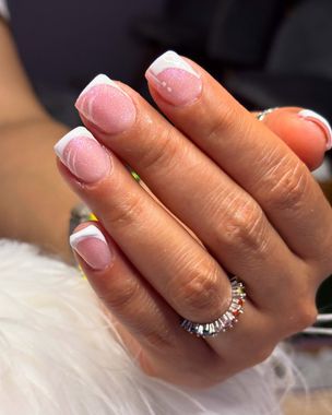 Mano con uñas cuadradas; manicura francesa con puntas blancas, base brillante y un anillo de color.