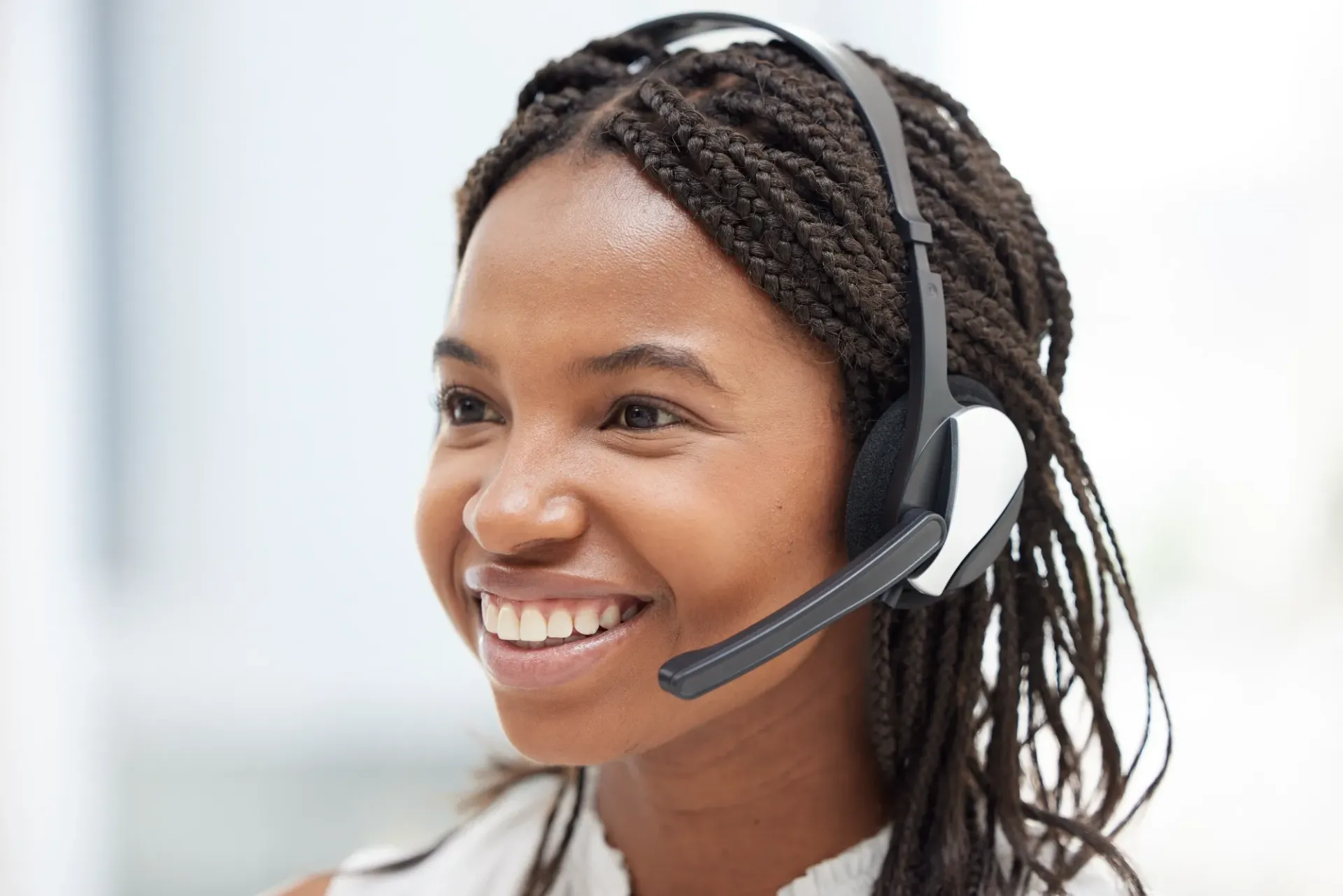 Smiling customer service agent wearing a headset in a bright office