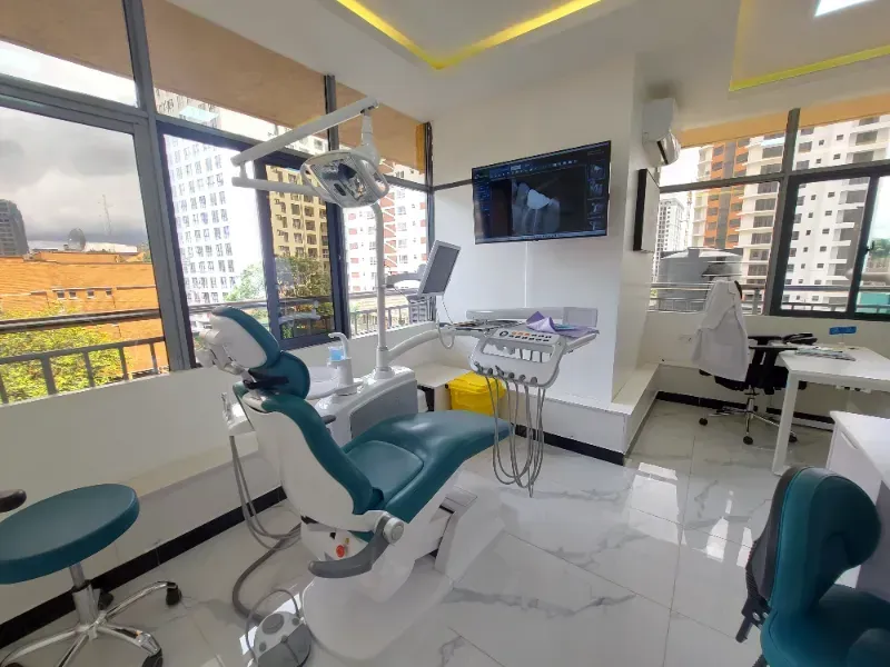 A dental office with a dental chair and a television on the wall.