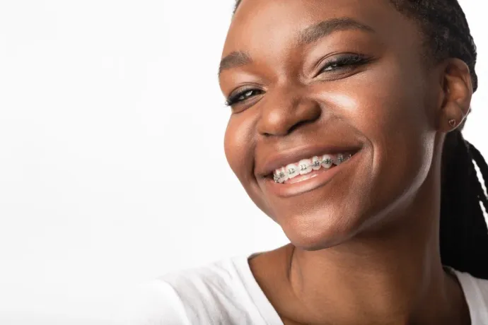 Smiling person with braces on a white background