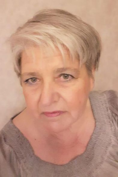 Portrait en gros plan de Maître Roucou portant un pull gris sur fond beige