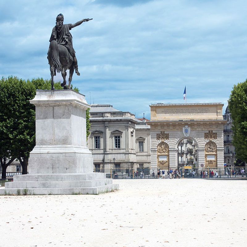 Statue équestre sur une place parisienne avec l'Arc de Triomphe du Carrousel en arrière-plan