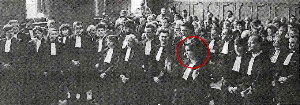 Foule en noir et blanc, assise en tenue de soirée ; une personne est mise en évidence par un cercle rouge.
