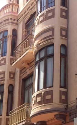 Un edificio con balcón y muchas ventanas.