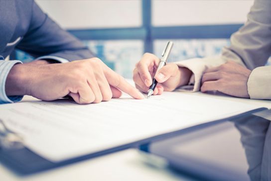 Un hombre y una mujer están firmando un documento.