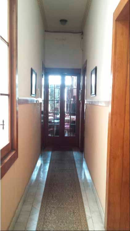 Un largo pasillo con alfombra y puerta.