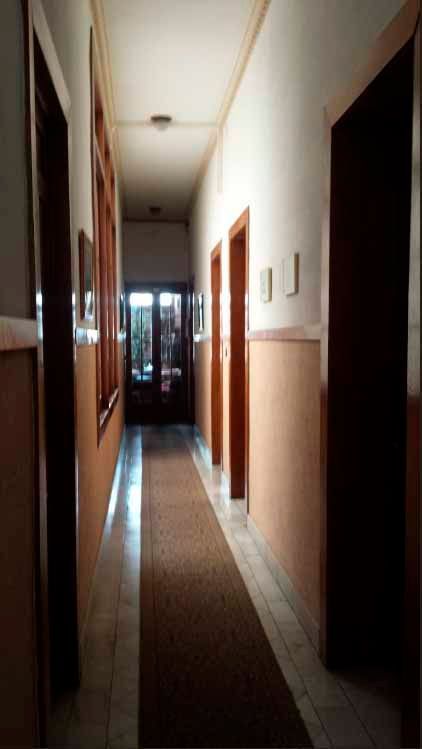 Un pasillo largo con alfombra y puertas en un edificio.