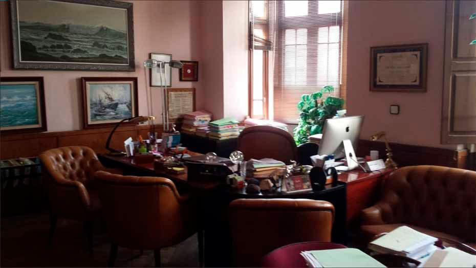 Una habitación con un escritorio y sillas y una computadora.