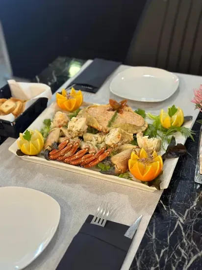 Un plato de comida está sobre una mesa con platos y utensilios.