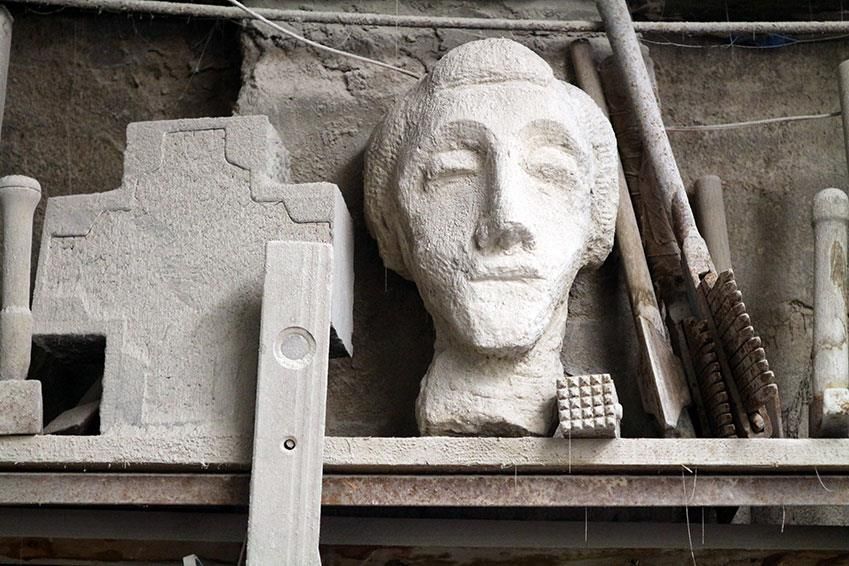 Eine Statue eines Männerkopfes sitzt auf einem Regal