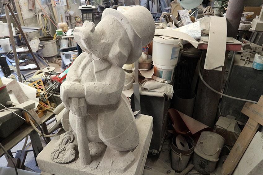 Eine Statue eines Mannes mit einem Regenschirm in einem unordentlichen Raum