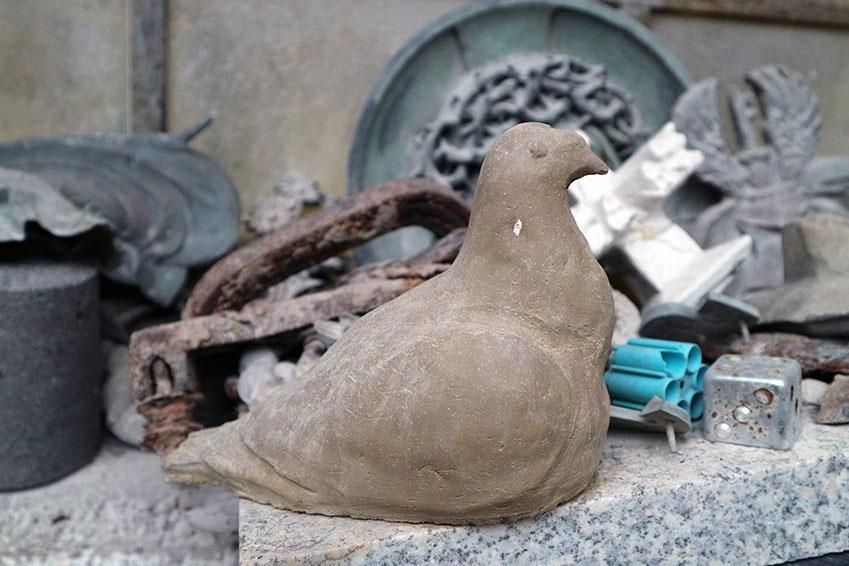 Eine Statue einer Taube sitzt auf einer Marmoroberfläche
