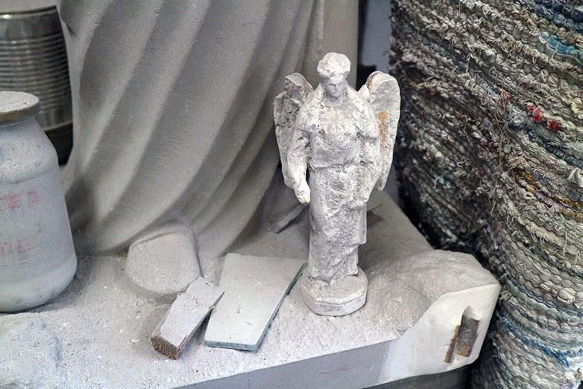 Eine kleine Statue eines Engels sitzt auf einem Tisch