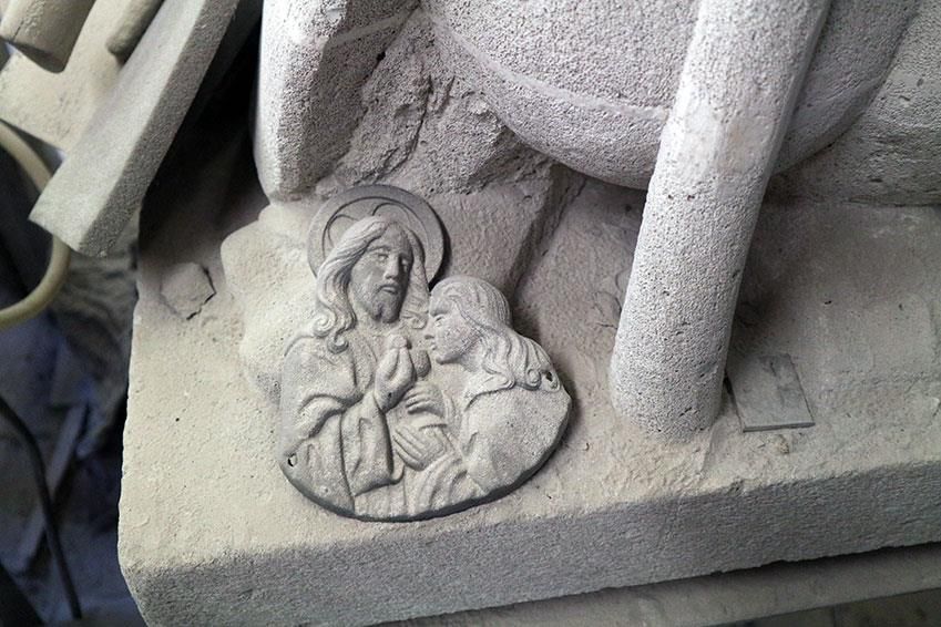 Eine Statue von Jesus sitzt auf einem Betonblock