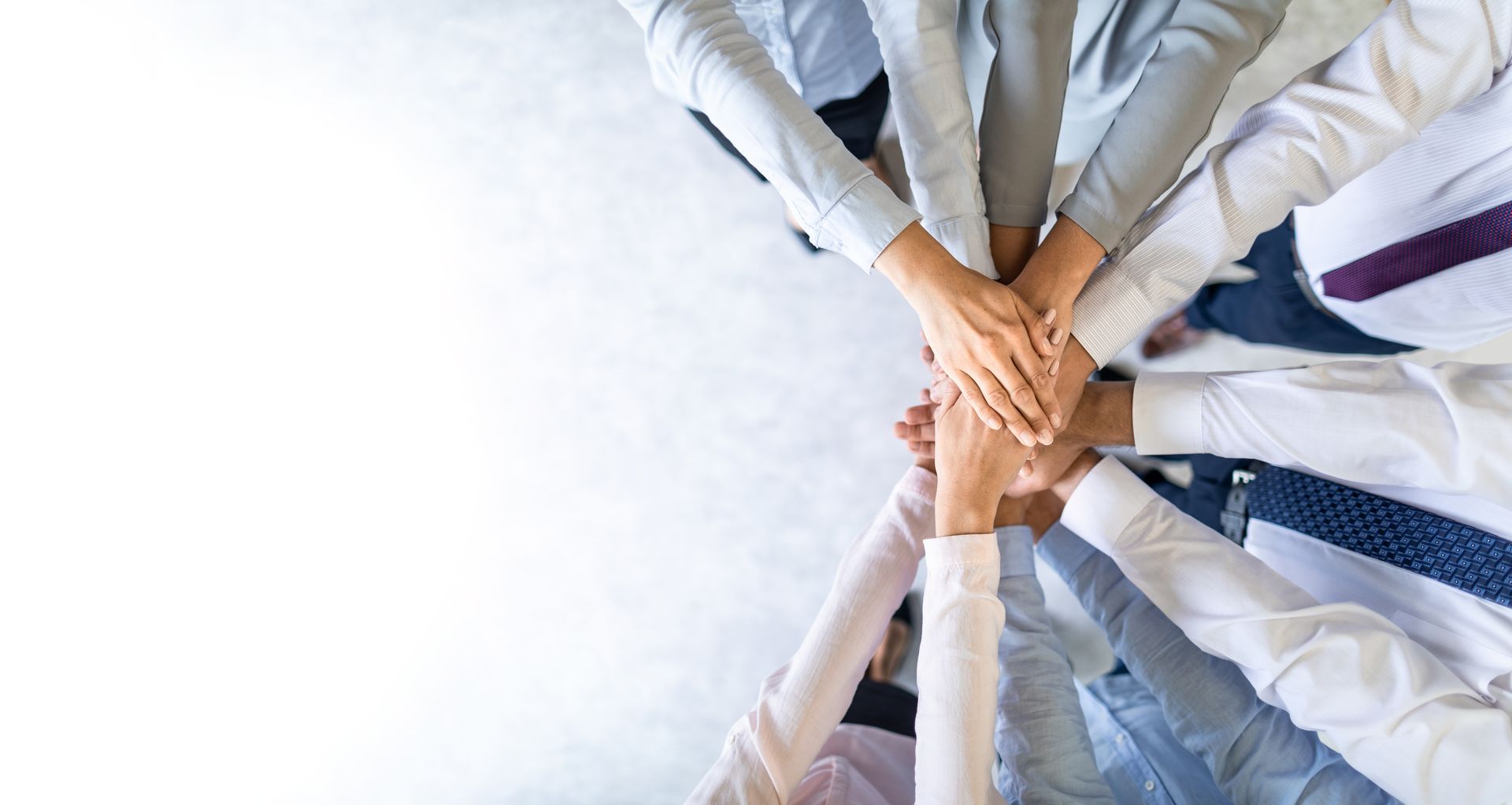 Vue en plongée de plusieurs mains professionnelles empilées en cercle.